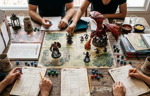 mesa de RPG, jogadores e dados com fichas de personagens.